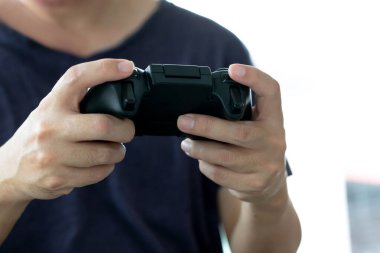 Video oyunları oynayan genç bir adam oyun denetleyicisi, seçilmiş odak parmakları