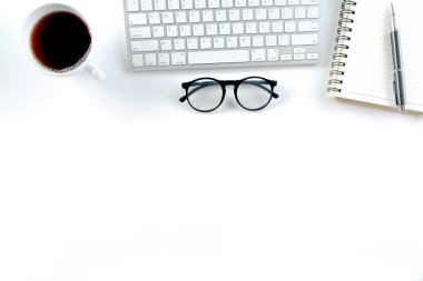 Klavye bilgisayarı, defter, ağaç, bardak ve kahve dolu modern beyaz ofis masası. Kopyalama alanı olan üst görünüm, düz yatay.