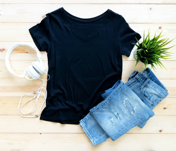 Siyah tişört modeli ve kahverengi ahşap arka planda kısa kot. Şablon, düz yat 