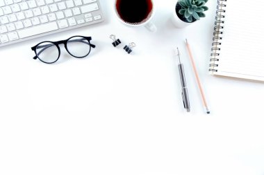 Klavye bilgisayarı, defter, ağaç, bardak ve kahve dolu modern beyaz ofis masası. Kopyalama alanı olan üst görünüm, düz yatay.