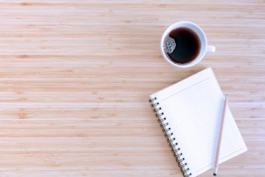 Düz kompozisyon, defter, kalem, kahve, ahşap arka planda bitki. Kavram