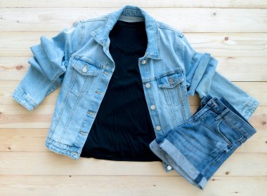 Siyah tişört modeli ve kahverengi ahşap arka planda kot pantolon. Şablon, düz yat