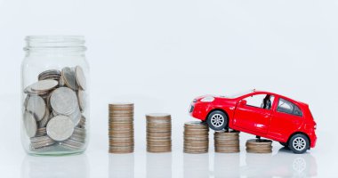 Cam şişede para biriktiriyorum. Bozuk paraların üzerine kırmızı minyatür araba oyuncağı koyun. konsept