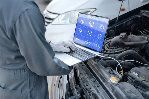 Wykwalifikowany Mechanik Korzystający Laptopa Sprawdzania Informacji Podczas Pracy Silnika Samochodowego — Zdjęcie stockowe