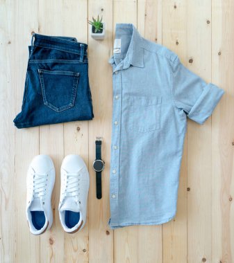 Ahşap zeminde erkek kıyafetleri ve eşyalar var.