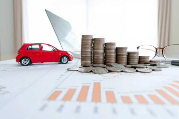 Car model and Financial graph with coins and laptop background. (finance, car loan and insurance concept)