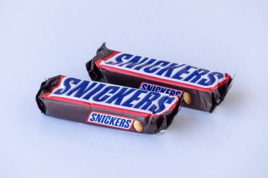 Bir çift tanınmış Snickers çikolatası, Mars, Inc. 'den özel bir ürün, eşsiz süt çikolatası, nougat, karamel ve fıstık karışımı içeriyor. Beyazlar üzerinde izole edilmiş ürün..