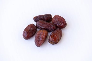 Beyaz arka planda izole edilmiş taze, lezzetli Medjool Hurma (Phoenix dactylifera) meyvelerinin yakın çekimi. Sağlıklı atıştırmalıklar, tatlı yiyecekler, enerji takviyesi ve Ramazan kavramları.