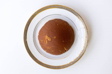 Lezzetli organik tarih jargonu ya da beyaz arka planda beyaz bir tabakta Khejur Gur küpü. Nolen Gur 'un kaliteli bir fotoğrafı. Tatlı yemeklerde kullanılan geleneksel bir Güney Asya tatlandırıcısı. Üst görünüm