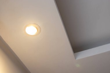Led spot ışıklarıyla döşenmiş tavan aydınlatmasının ayrıntıları. Düşük alçı tavan, modern iç tasarım, mimari ve dekoratif ışıklandırmayı temsil eden dokulu bir duvara yöneltilmiş ışığı vurgular..