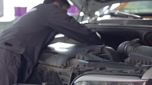 Mecánico de coche trabajando con motor de coche — Vídeos de Stock