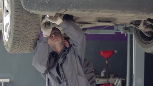 Hombres revisando fondo del coche — Vídeo de stock