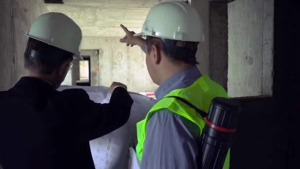 Architect and foreman looking at development plan — Stock Video