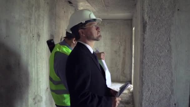 Architecte et contremaître discutant du plan de construction — Video