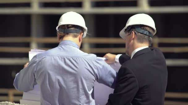 Разработчики рассматривают план строительства — стоковое видео