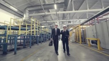 İki işadamları fabrika ile yürüyüş