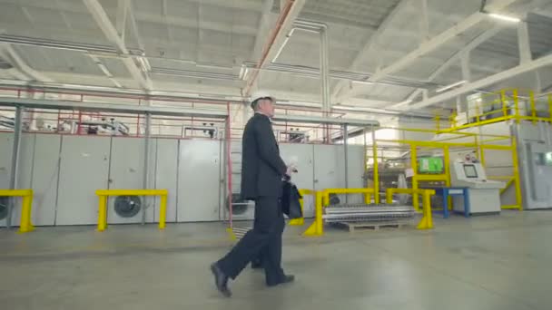 Businessmen walking through industrial factory — Stock Video