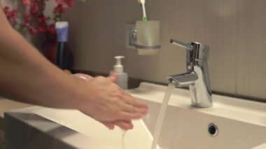 Ellerimi sabunla yıkıyorum.