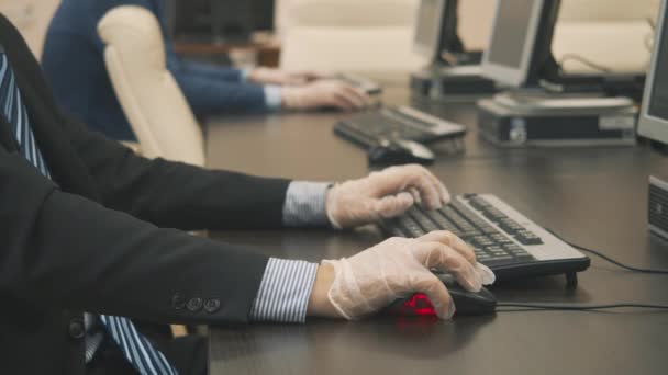 A person works on a computer wearing disposable gloves — Stock videók
