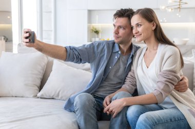 Akıllı telefon ekranına bakan neşeli çift.