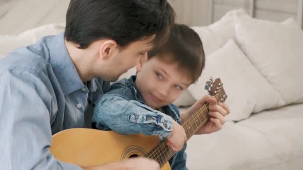 Apa megtanítja a fiát gitározni. — Stock videók