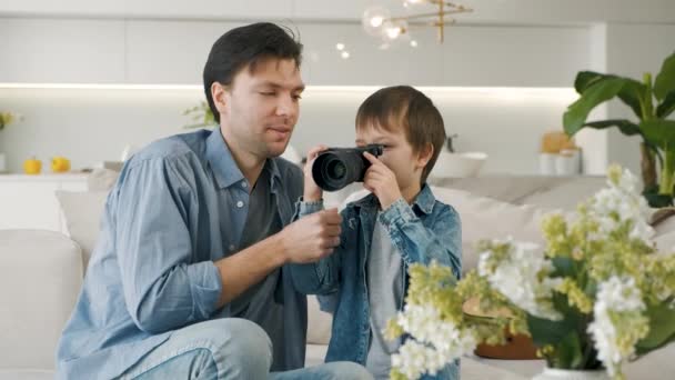 Vater lehrt seinen Sohn, Kamera zu benutzen — Stockvideo