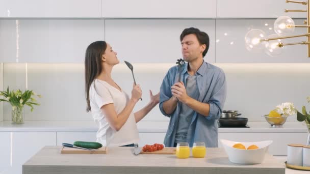 キッチンで楽しい時間を過ごしている陽気なカップル — ストック動画