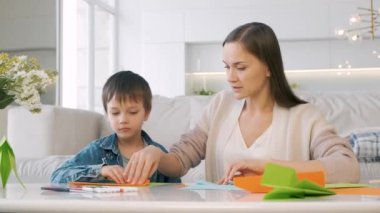 Anne ve oğul origamiyi katlıyor.