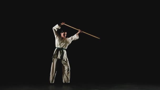 Młoda kobieta w kimono ćwiczy z jodo — Wideo stockowe