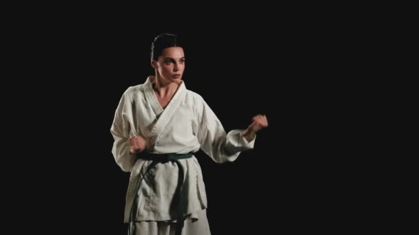 Vrouw in kimono oefent karate kicks — Stockvideo