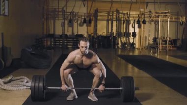 Atletik adam halter kapmaca oynuyor.