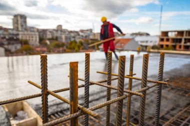 Islak beton zeminde duran inşaat işçisi. Yerdeki çelik parmaklıklardan kamyona ıslak çimento transferi için hazır ve nazır..