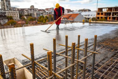 Islak beton zeminde duran inşaat işçisi. Yerdeki çelik parmaklıklardan kamyona ıslak çimento transferi için hazır ve nazır..