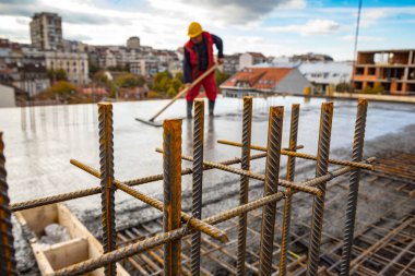 Islak beton zeminde duran inşaat işçisi. Yerdeki çelik parmaklıklardan kamyona ıslak çimento transferi için hazır ve nazır..