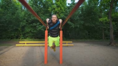 Park kaslı adam onun iş sırasında. Göğüs ve triceps dips, egzersiz.