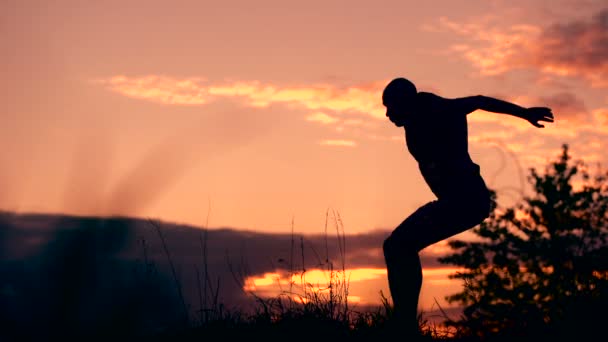 Gezonde jonge man springen bij zonsondergang — Stockvideo