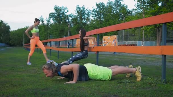 Jeune couple de santé faire de l'exercice d'étirement relaxant et réchauffer après le jogging et la course dans le parc — Video