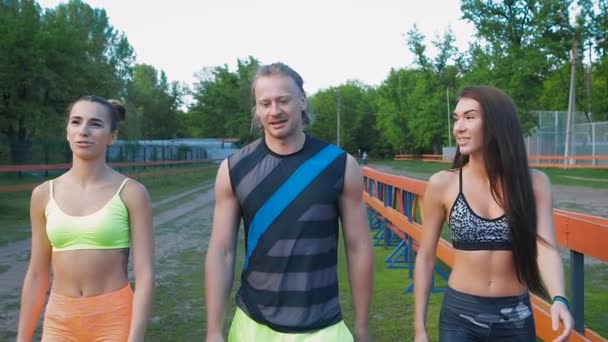 Tres personas caminando en un parque, haciendo ejercicio — Vídeos de Stock