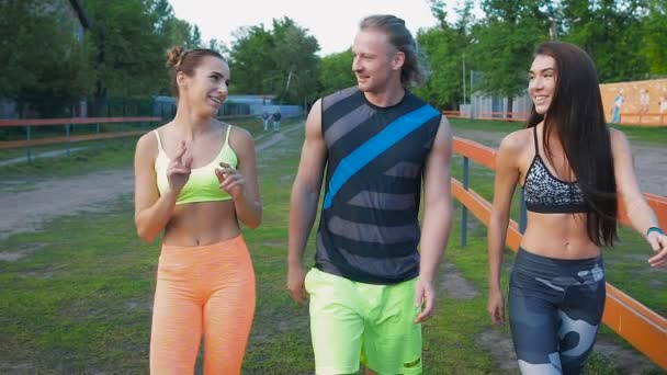 Estilo de vida deportivo. Jóvenes de buen humor después de un entrenamiento hablando . — Vídeos de Stock