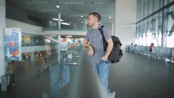 Elegante hipster en el aeropuerto esperando la llegada de la aeronave . — Vídeo de stock