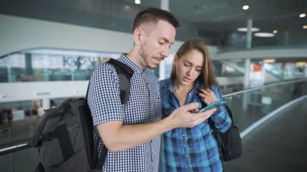 Ten ukazuje něco na smartphone se svou přítelkyní. — Stock video