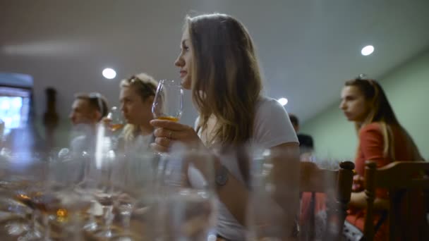 Gruppo di giovani in degustazione. Ragazza con un bicchiere di vino, assaggia il gusto e l'odore della bevanda . — Video Stock