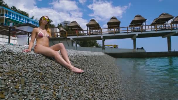 若い魅力的な女性リラックスしたビーチで。彼女はリラックスして幸せ. — ストック動画