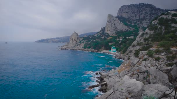 Eglise catholique et protestante sur la plage, au pied de la montagne .