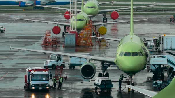 Международный аэропорт инфраструктуры. Самолёты на площадке, персонал выполняют необходимые ремонтные работы — стоковое видео