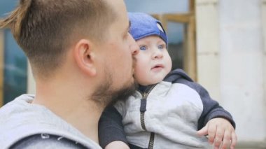 Baba ve genç oğlu. Bir sakallı bir adam onun kollarında bir bebek tutan,