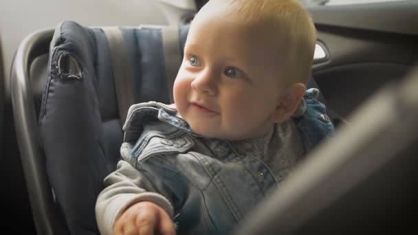 Seguridad en el coche para los niños. Niño sentado en un asiento de coche especial — Vídeo de stock