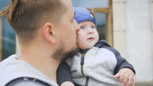 Padre e figlio. Un uomo con la barba, che tiene un bambino tra le braccia , — Video Stock