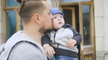 Baba ve genç oğlu. Bir sakallı bir adam onun kollarında bir bebek tutan,