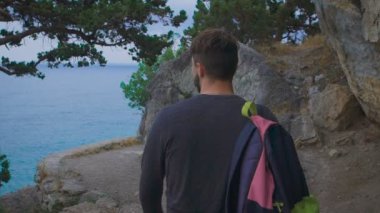 Kenar ve çarpıcı manzaralarına bakan uygun sırt çantası ile genç yenilikçi.